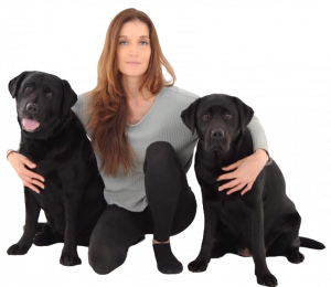 The author,  Anna Francesca Bradley, sitting on the floor with two large, black, sweet-looking dogs.
